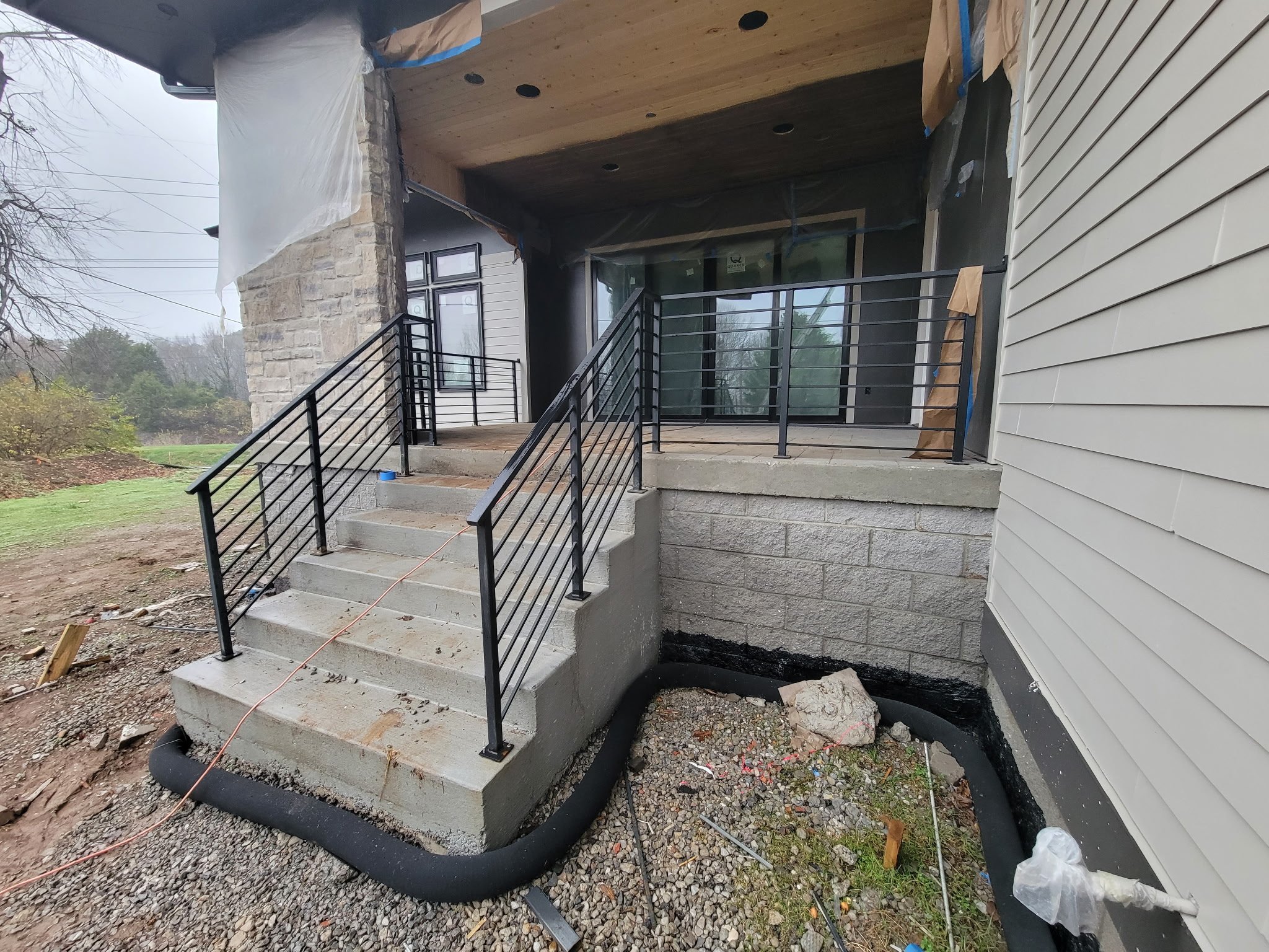 Custom modern residential entry handrail system. Features a sleek horizontal bar design with clean geometric lines, precision-crafted to accent high-end contemporary home architecture and porch entries.
