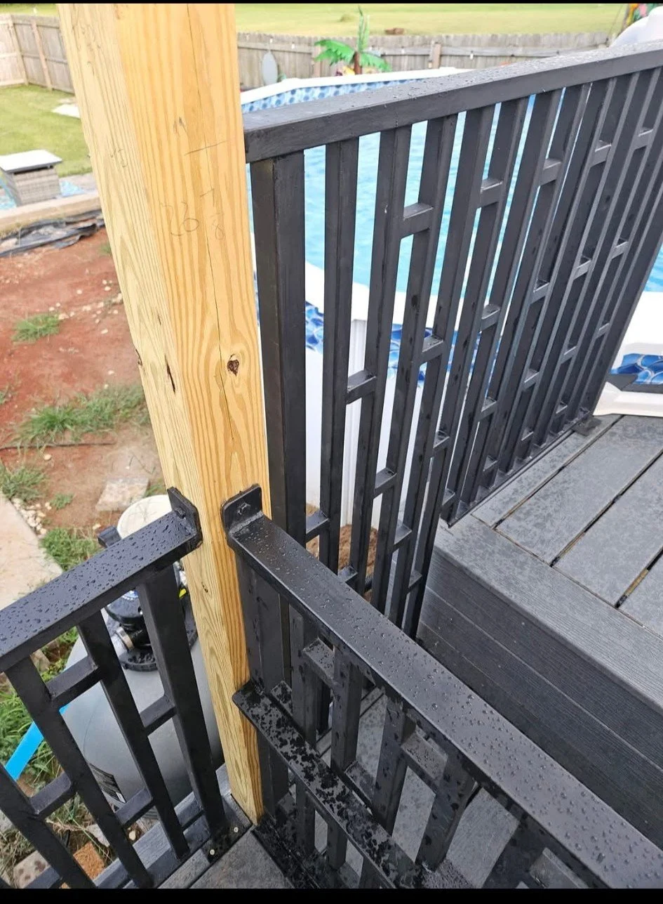 Custom residential steel deck and pool-side safety railing. Features a durable matte black finish with clean vertical pickets, precision-welded and securely mounted to wood decking to provide a sleek, low-profile barrier that ensures premium safety w