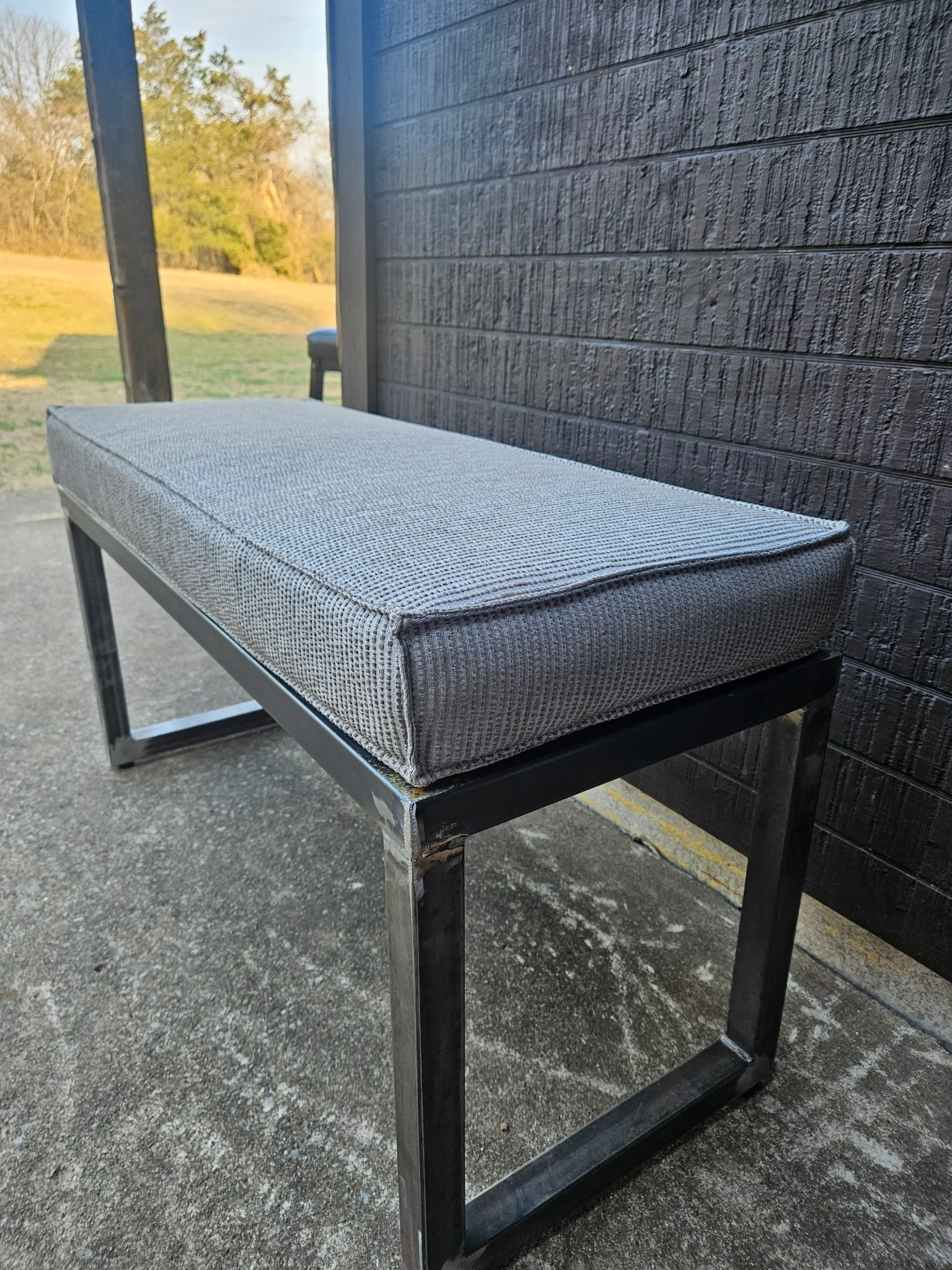 Custom modern industrial upholstered bench. Features a precision-welded, heavy-duty steel base with a sleek black finish, perfectly paired with a premium patterned cushion for a luxury entryway or living space.