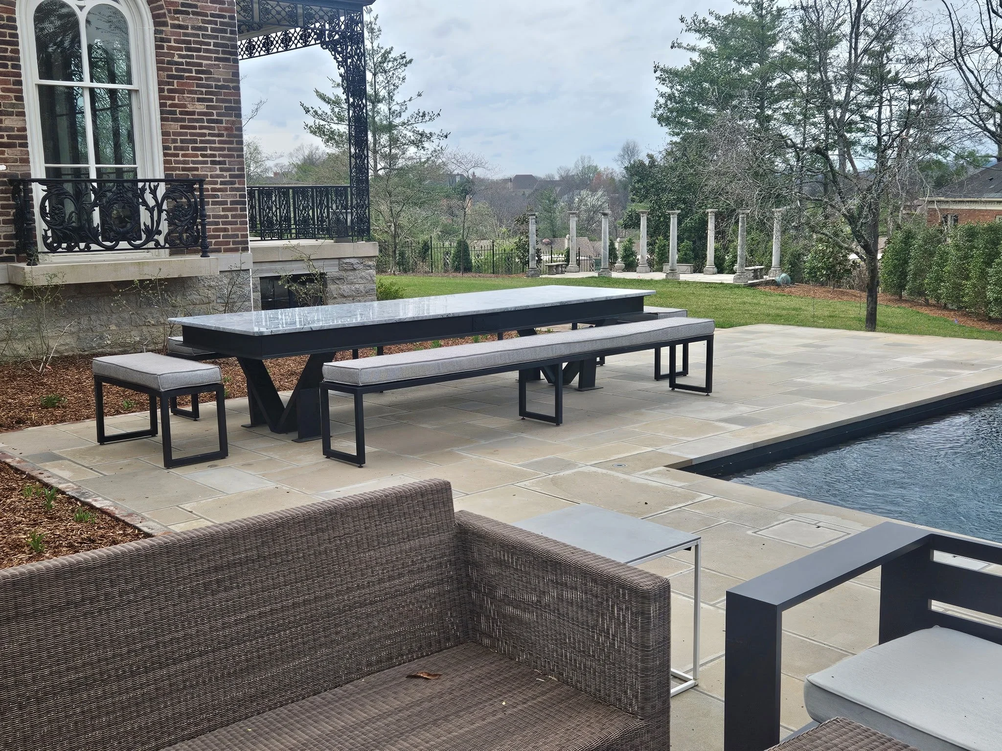 Custom industrial outdoor patio dining table and matching bench set. Precision-fabricated with a heavy-duty, clean-lined steel frame and a weather-resistant top, engineered to bring sleek architectural design to luxury outdoor living spaces.