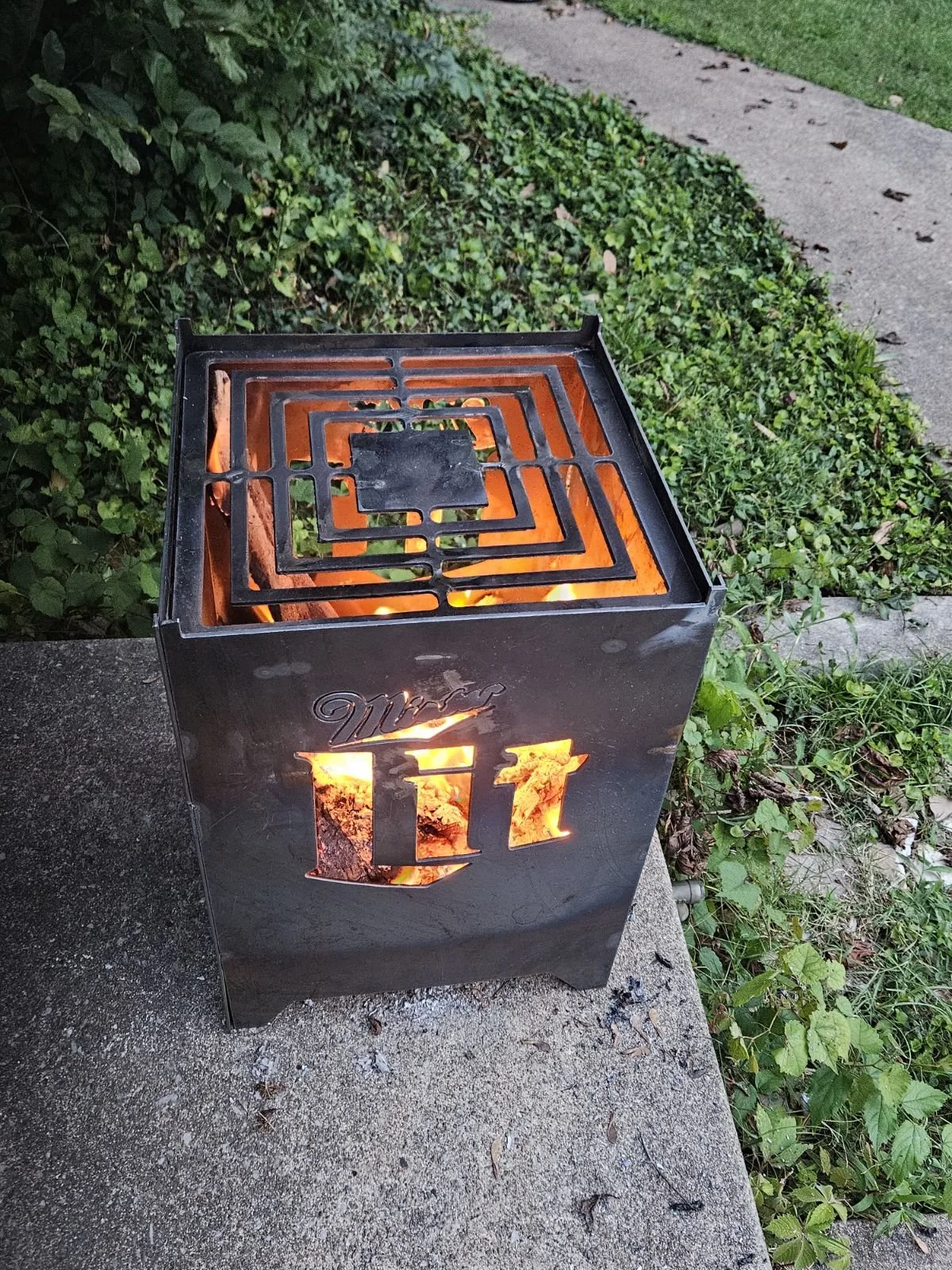 Handcrafted square backyard fire pit with intricate CNC plasma-cut geometric ventilation patterns, combining clean aesthetics with durable steel construction.