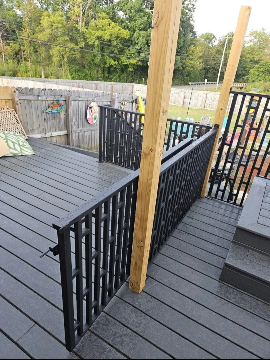 Custom exterior steel deck and stair handrail system. Precision-fabricated with a clean vertical picket design and a durable matte black finish. Engineered for seamless integration alongside existing structural posts and composite decking, providing 