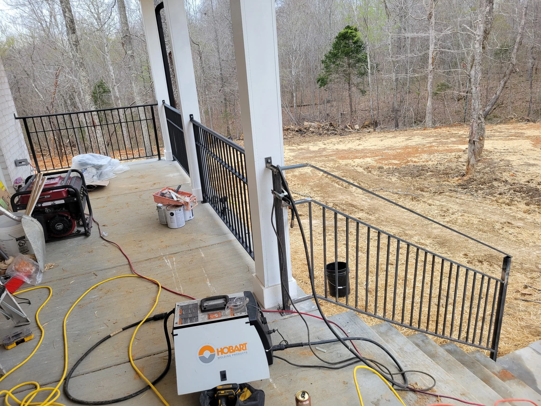Custom residential porch railing installation. Handcrafted steel handrails precision-fitted and securely anchored on-site, demonstrating a clean, professional finish from start to finish.