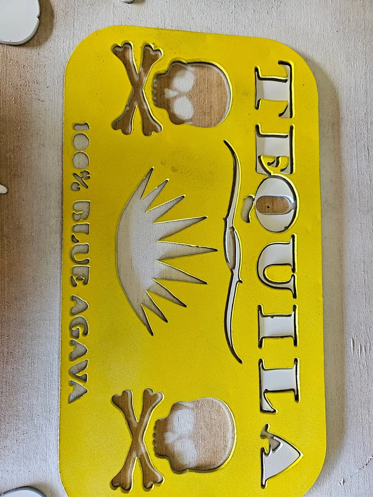 Custom CNC plasma-cut "Tequila" steel sign. Features a vibrant yellow powder-coated finish with intricate skull and agave plant cutouts, perfect for custom home bars, outdoor patios, or commercial tavern decor.