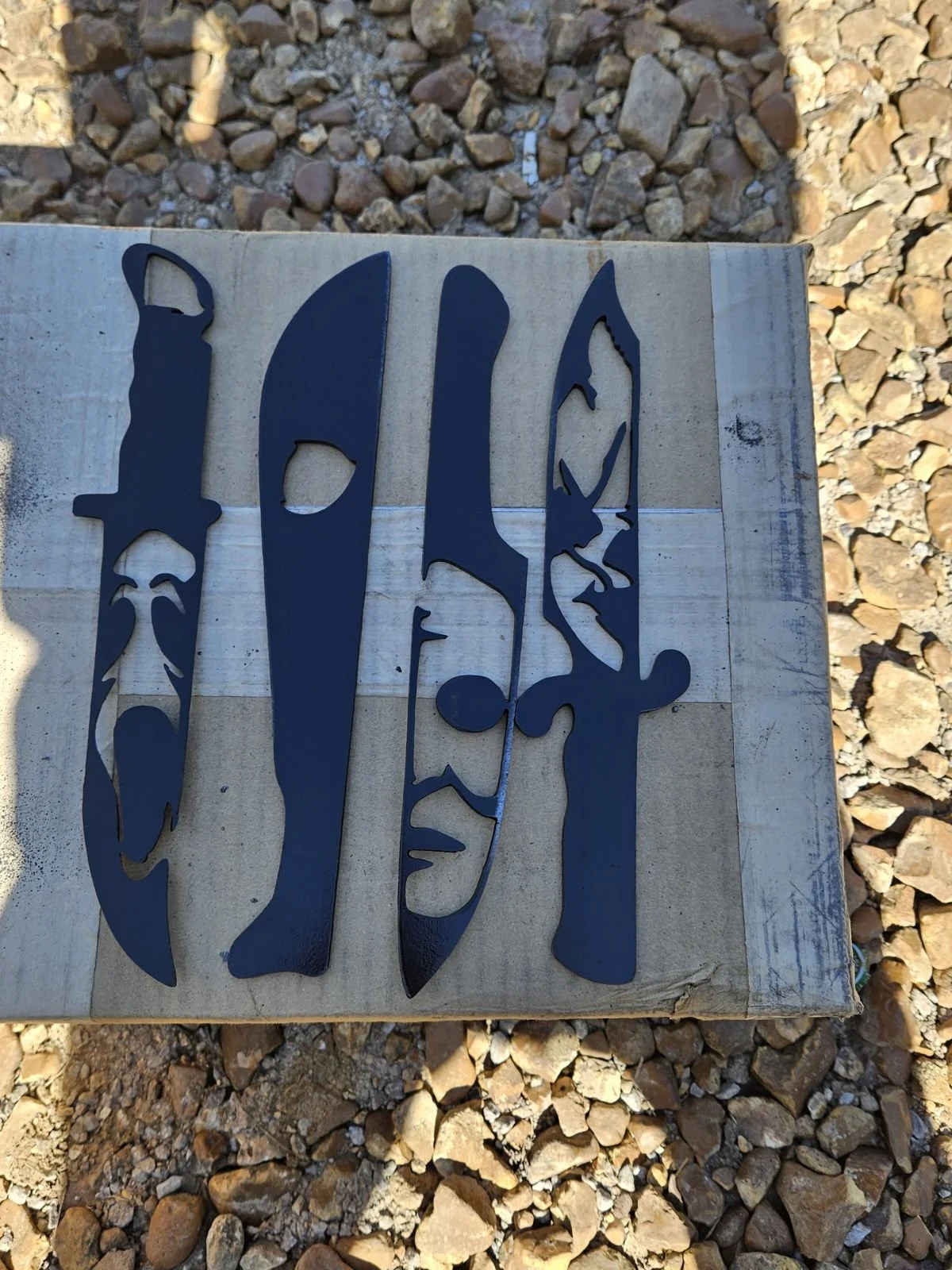 Custom CNC plasma-cut steel tactical knife silhouette display. Features precision-engineered blade profile cutouts on a heavy-duty steel plate, showcasing flawless edge detail for industrial wall art or specialized collector displays.
