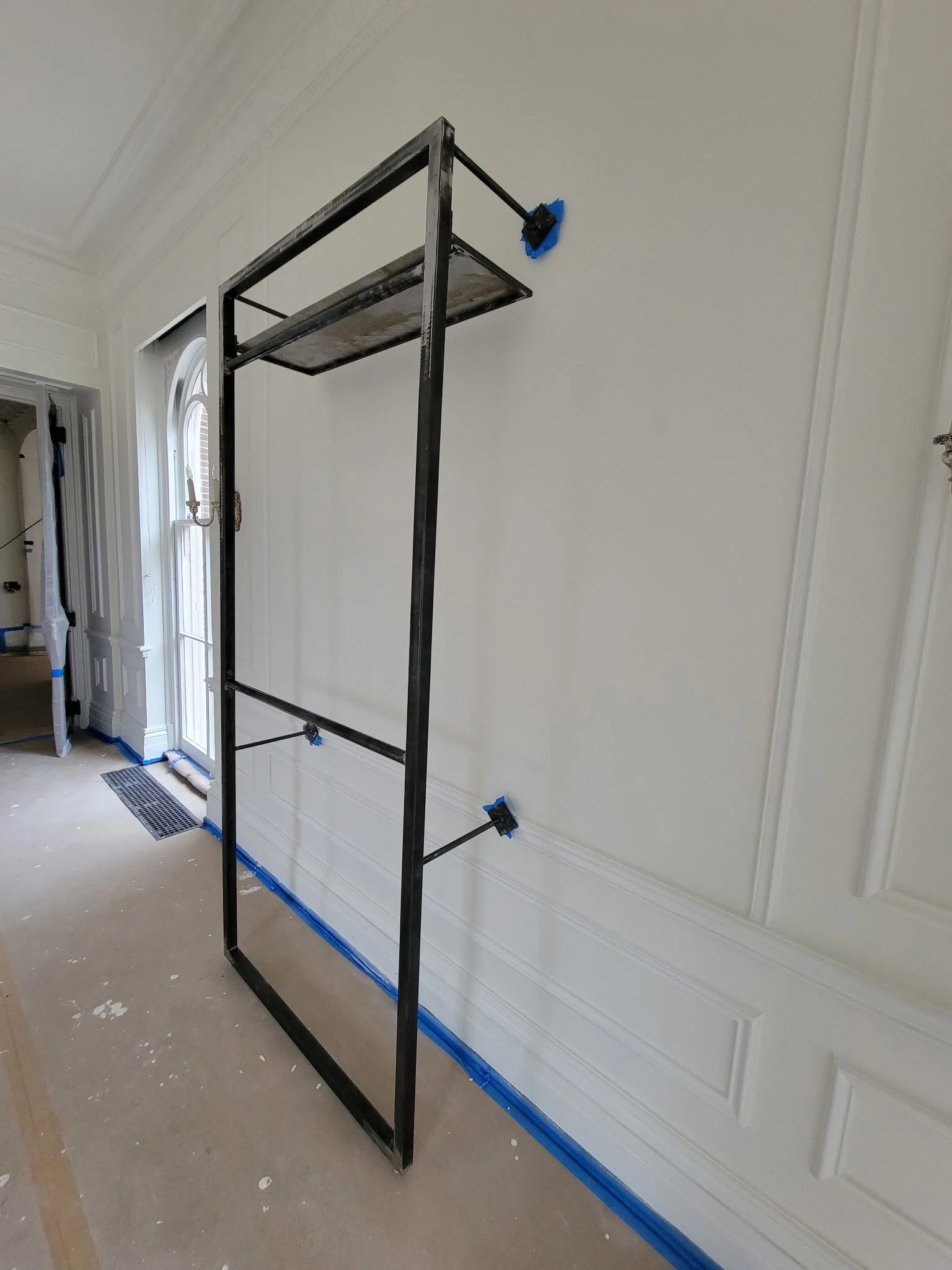 Custom industrial wall-mounted clothing rack. Handcrafted from durable steel tubing with a clean black finish, precision-welded to provide heavy-duty garment storage for retail displays or modern home closets.