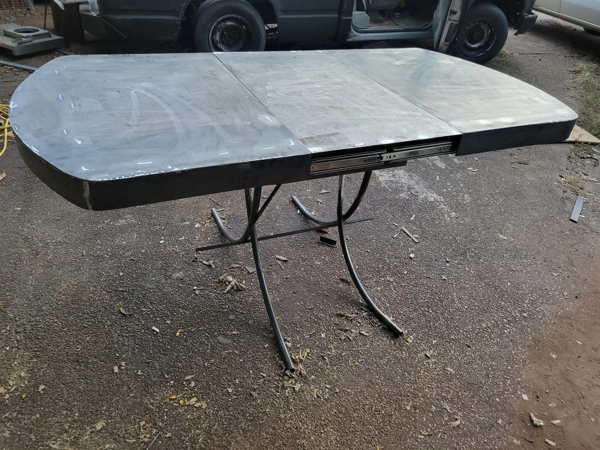 Custom hand-crafted modern industrial dining table. Showcasing the sleek, durable tabletop paired perfectly with a bespoke, precision-welded architectural steel base for an upscale home or commercial space.
