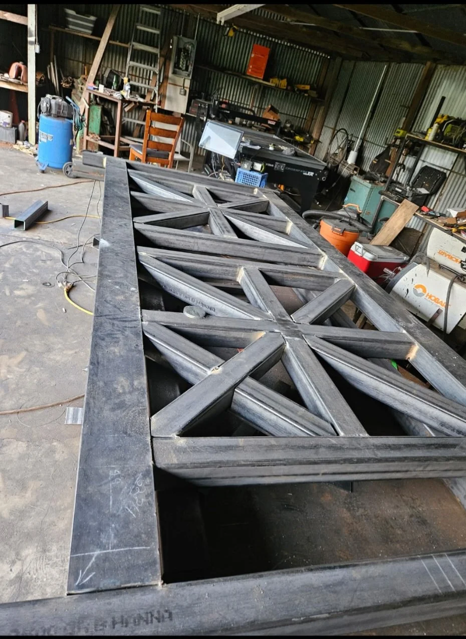Heavy-duty structural steel frame under construction. Detail shot of the industrial fabrication process, showcasing clean layout work, robust structural reinforcement, and precise fitment before final finishing.