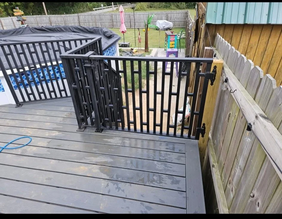 Custom-fabricated residential steel deck gate. Features a striking modern geometric picket design finished with a durable, weather-resistant matte black coating. Precision-welded and engineered with heavy-duty hinges to provide a secure, seamless ent