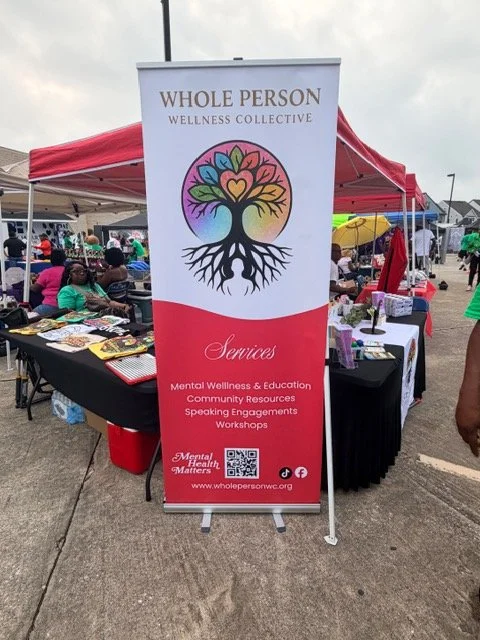 A tall vertical banner for Whole Person Wellness Collective, featuring a colorful tree with roots and a heart-shaped symbol in the branches. The banner lists services including mental wellness, education, community resources, speaking engagements, and workshops, and includes a website link.