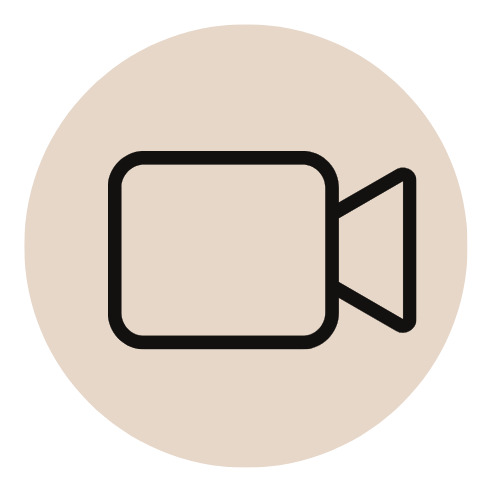 Icon of a vintage video camera on a beige circular background.