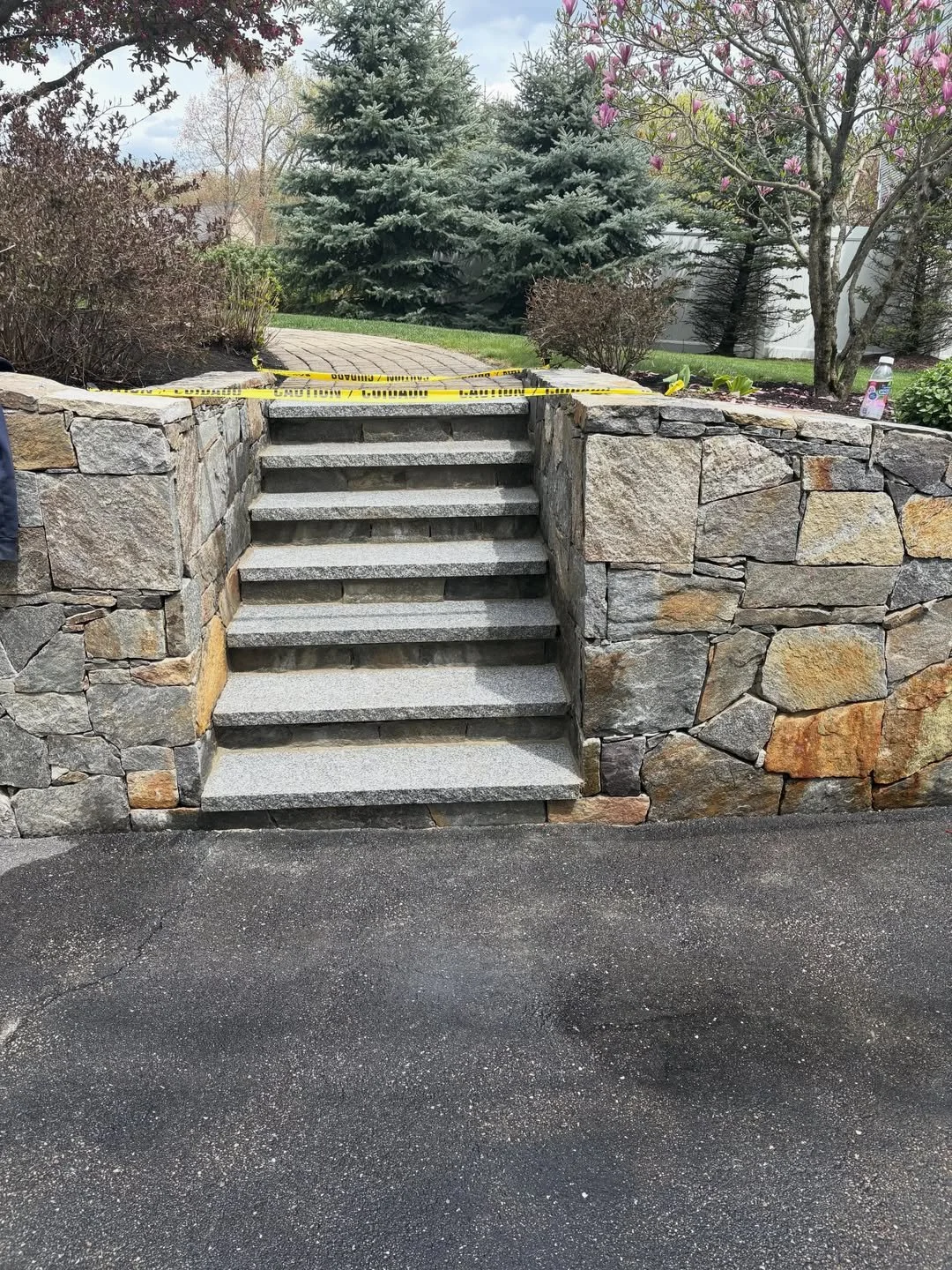 Custom granite staircase and retaining wall landscape construction project in New Hampshire