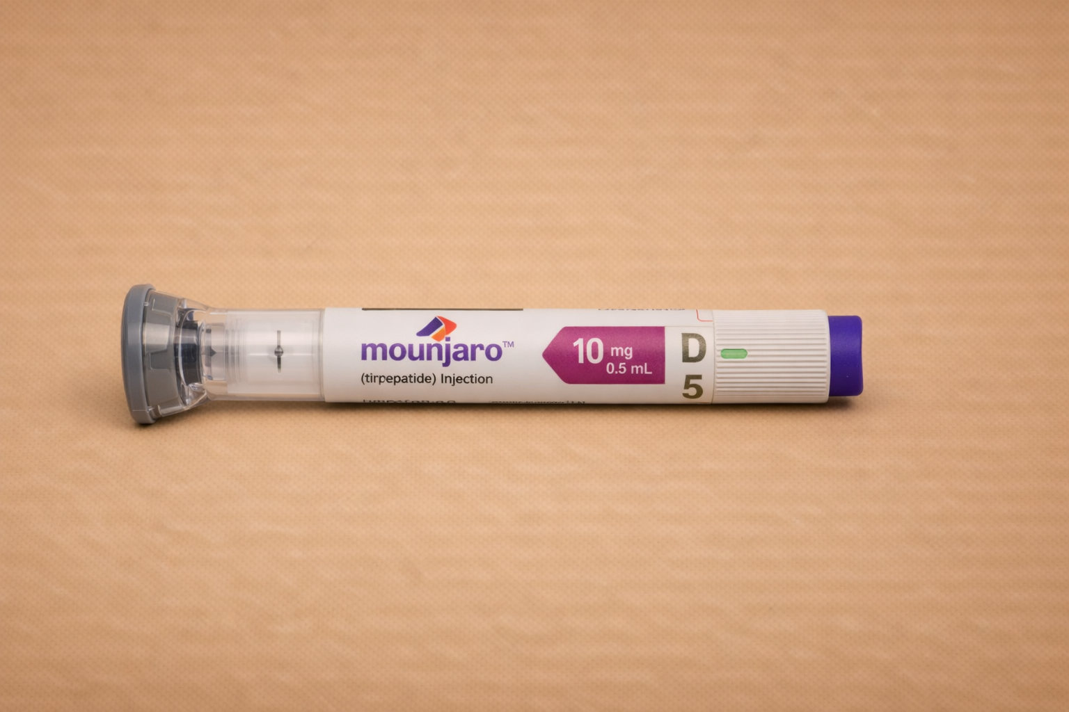 Injectiespuit met medicatie, label met teksten 'mounjaro', '10 mg', '0.5 mL', en 'tirzepatide' op een houten oppervlakte.