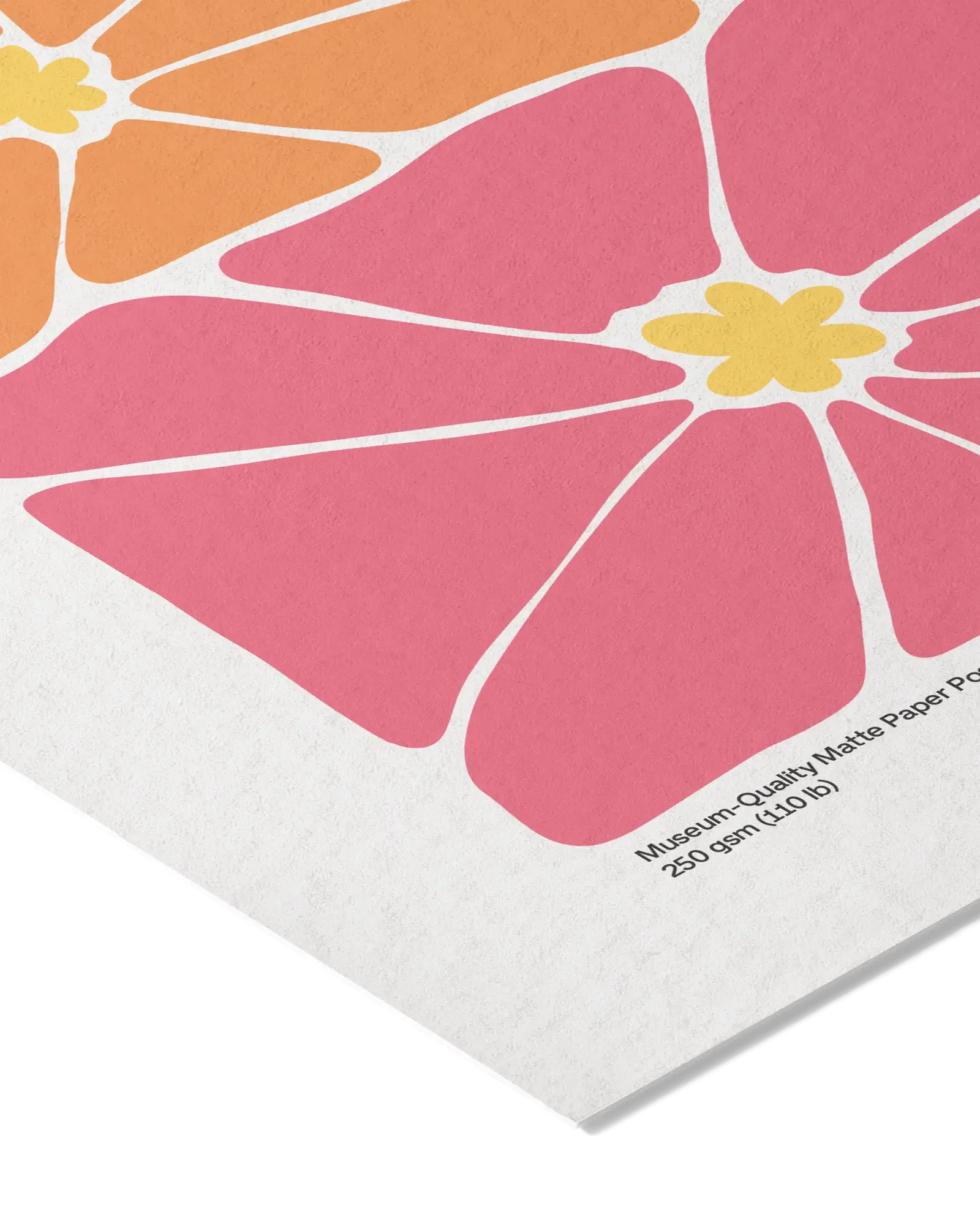 Close-up of a piece of matte paper with a colorful floral design featuring pink, orange, and yellow sections, and small printed text at the bottom.