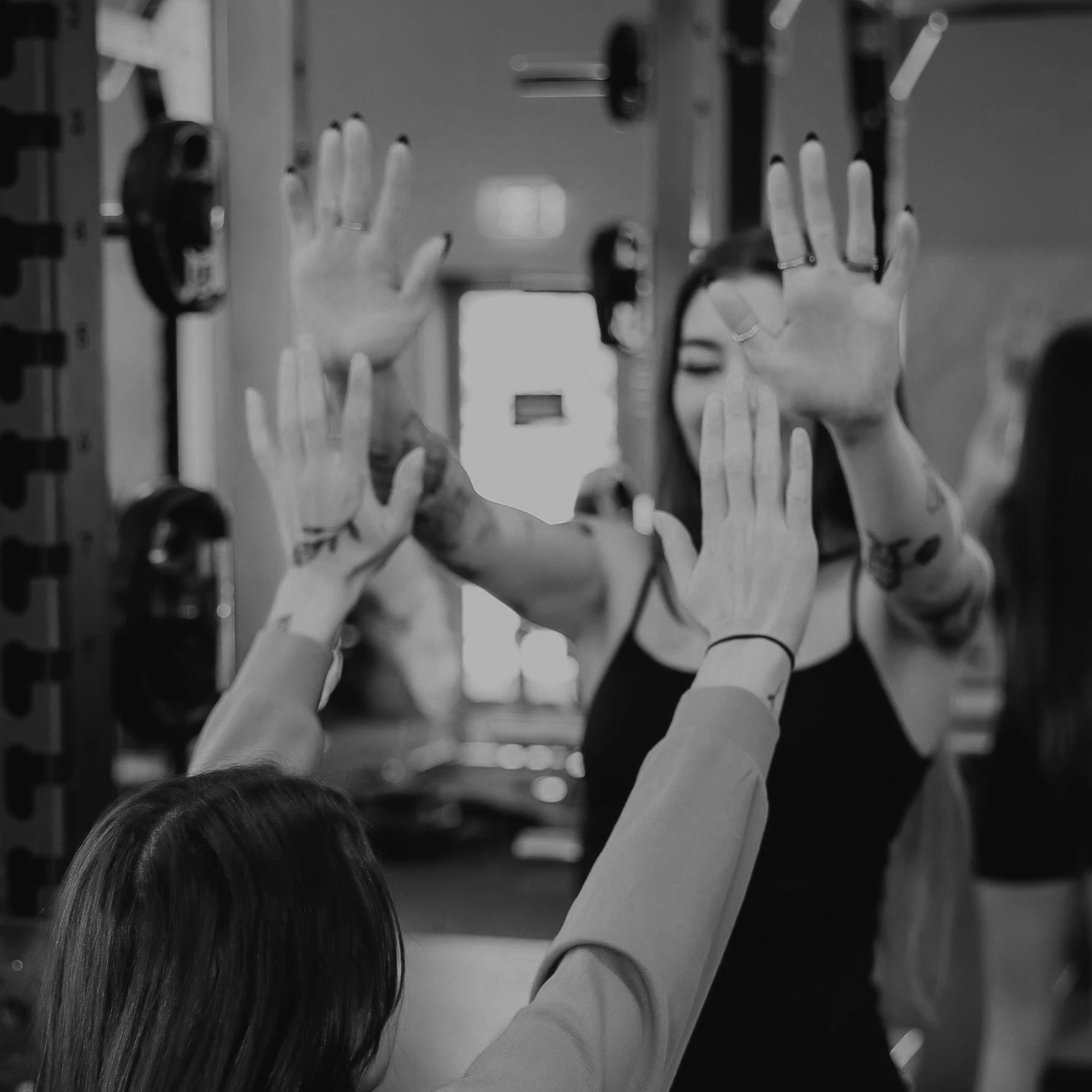 Children with prosthetic arms reaching up towards a mirror in a classroom or therapy setting, with blurred background.