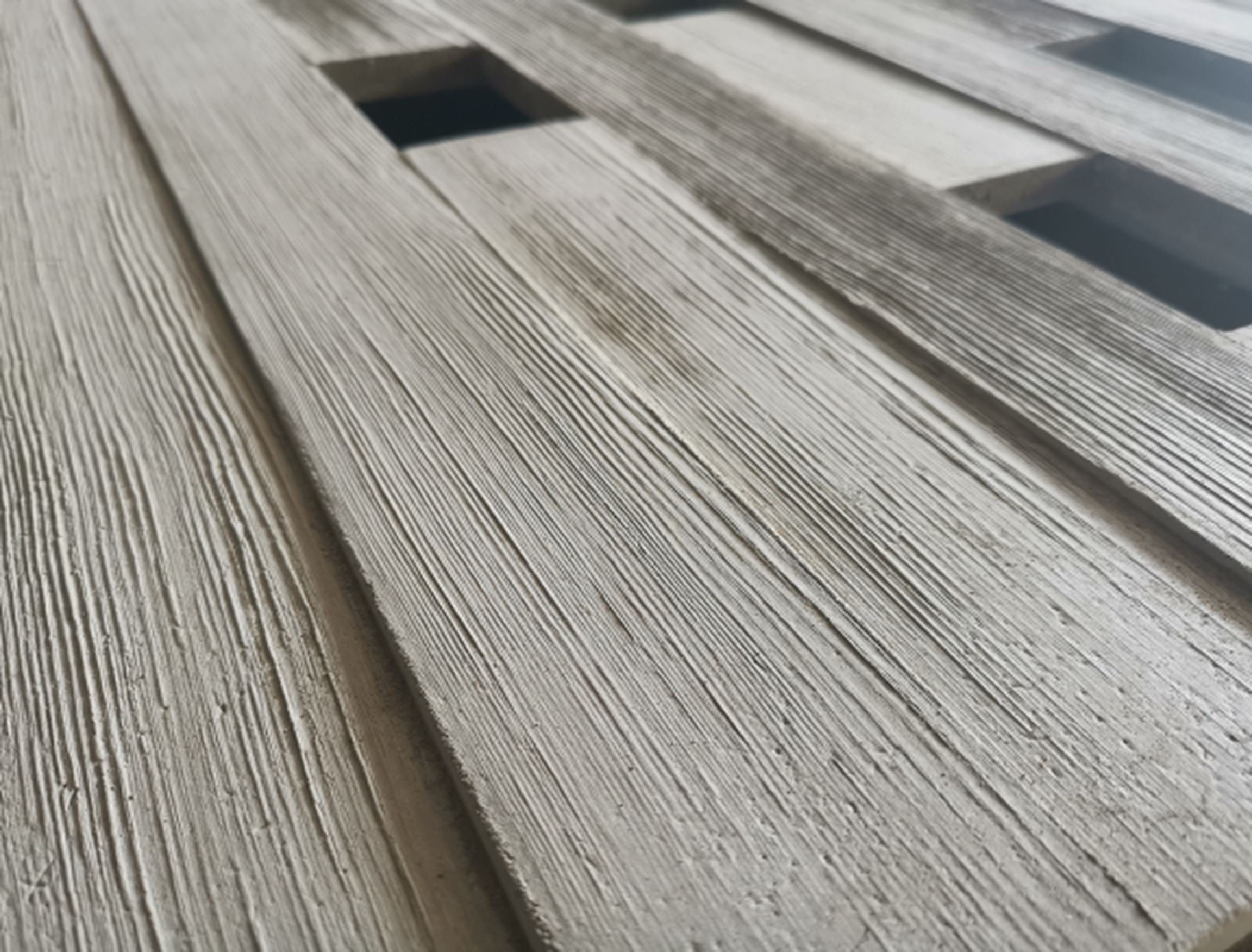 Close-up of weathered wooden slats with a square opening or vent in the surface.