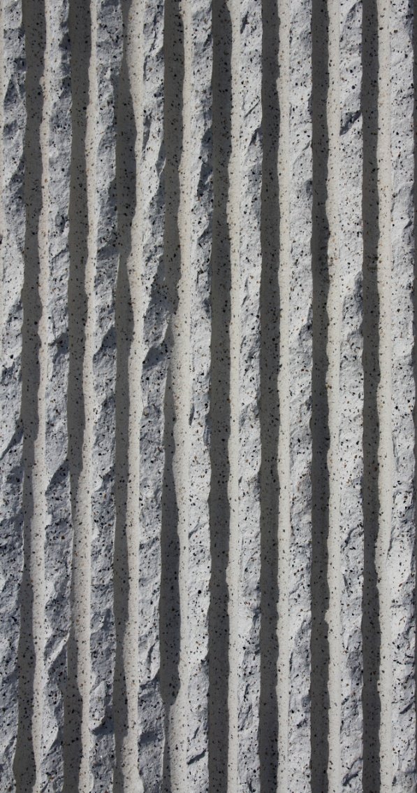 Close-up of a textured concrete wall with vertical streaks.