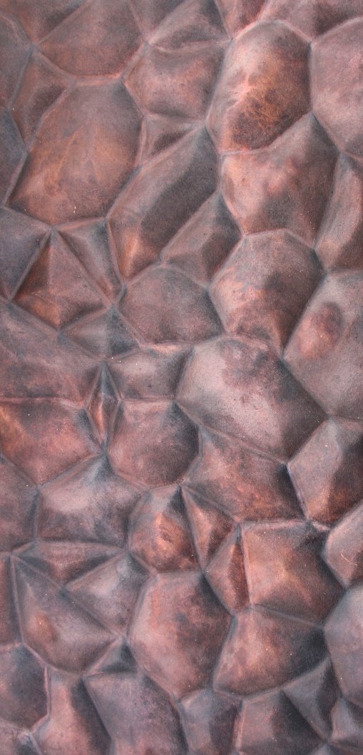 Close-up of a textured stone surface with irregular, angular stones in reddish-brown hues.