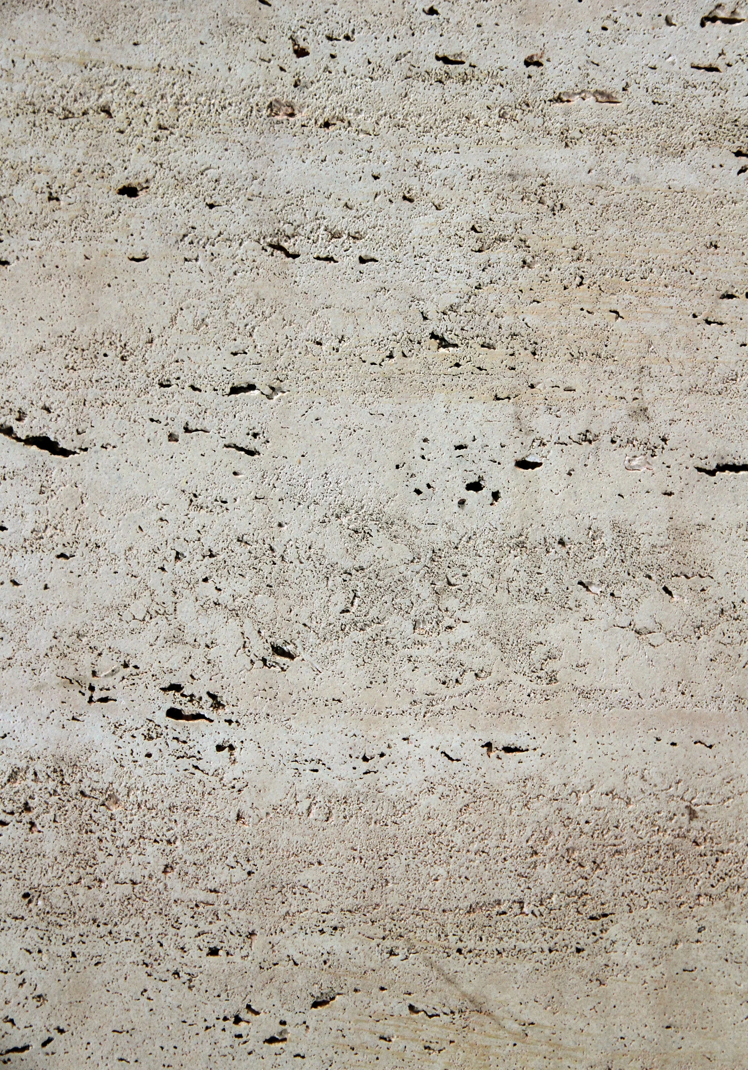 Close-up of a sandy surface with small holes and uneven texture.