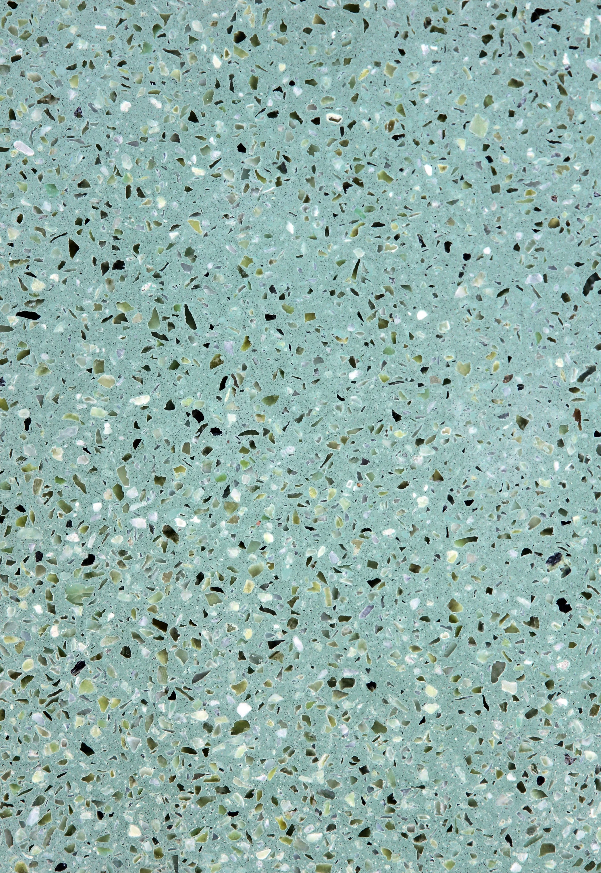 Close-up of a green terrazzo surface with multicolored aggregate chips.