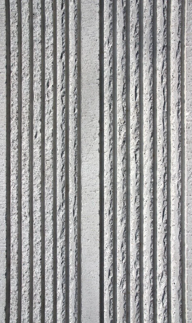 Close-up of a textured concrete wall with vertical grooves.