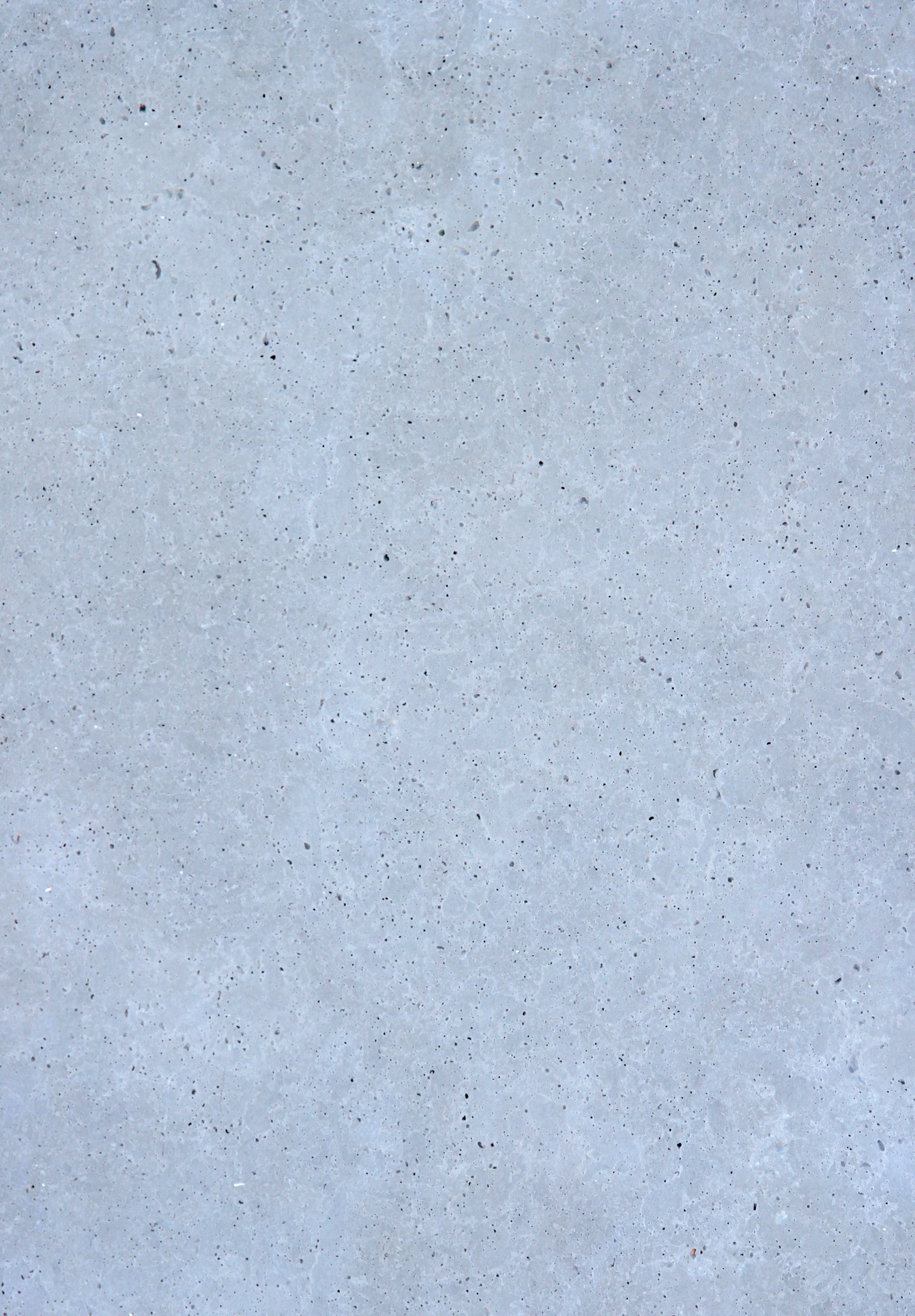 Close-up of a concrete surface with small dark and light speckles.