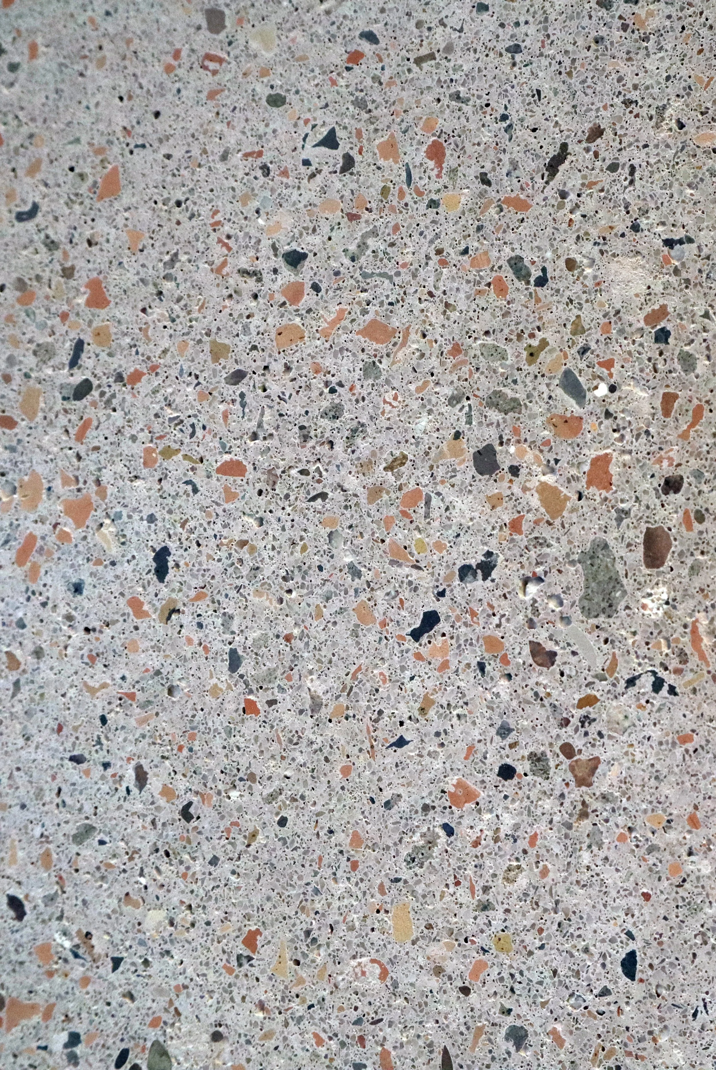 Close-up of a speckled, multicolored terrazzo surface with various small stone chips embedded in concrete.