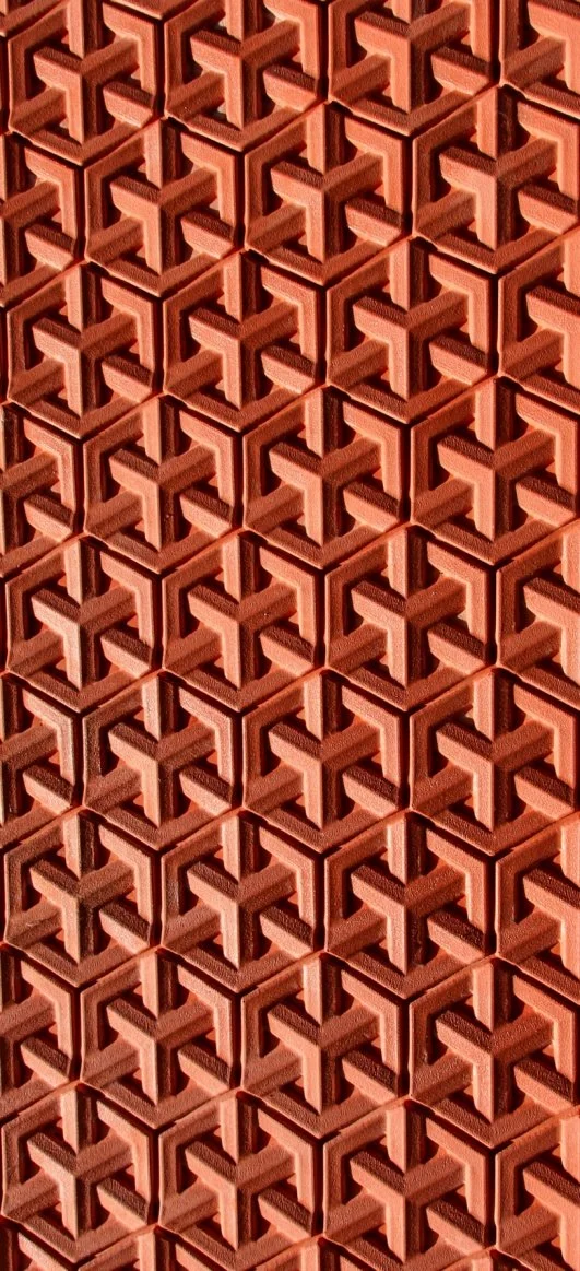 Close-up of a stack of red brick blocks with interlocking or geometric pattern.