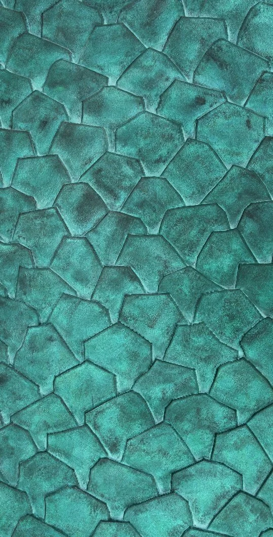 Close-up of turquoise-colored cracked stone surface.