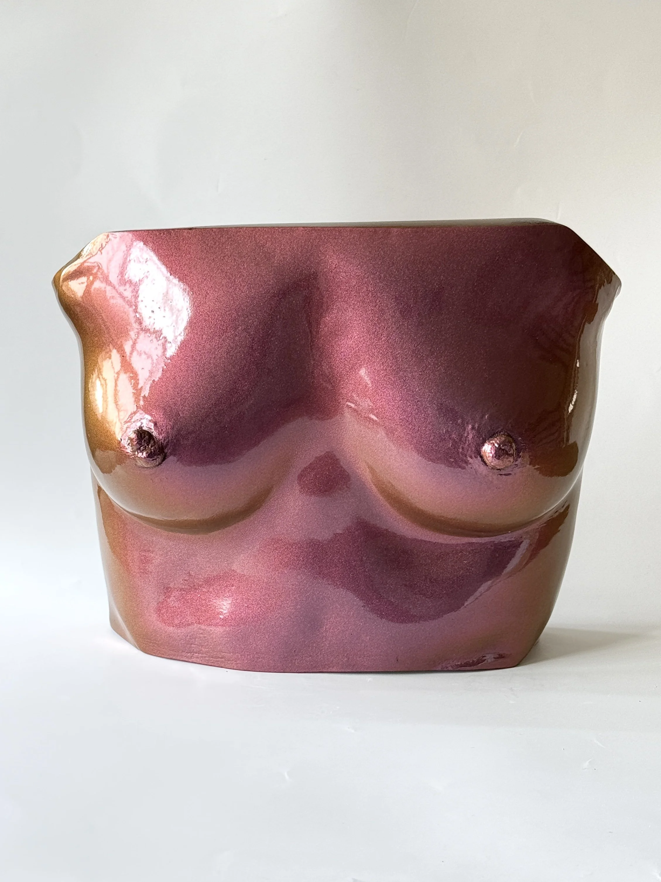 A red handcrafted soap shaped like breasts, placed on a white background.