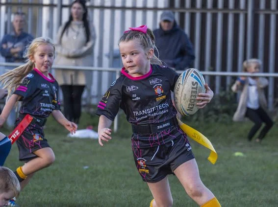 Young Skirlaugh Girls player carrying the rugby ball during a game.