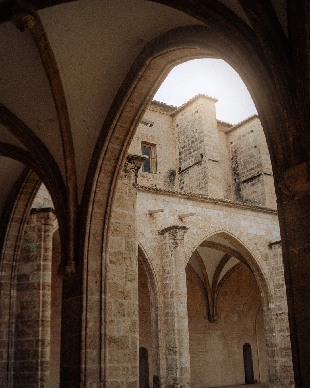 View of an ancient stone church or cathedral with arches and towers, seen from inside.