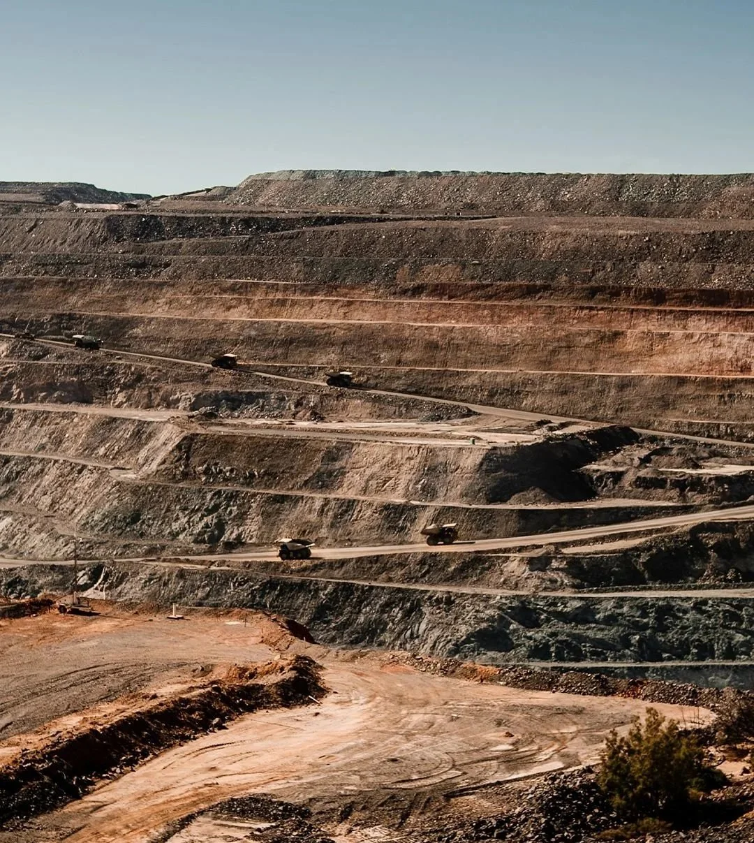 Open cut gold mine with haul trucks on bench roads, Western Australia