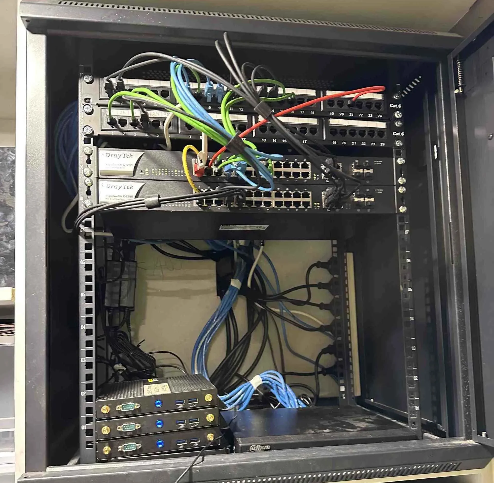Open server or network equipment rack with multiple network cables and modules installed, some labeled with brand 'Dahua'.