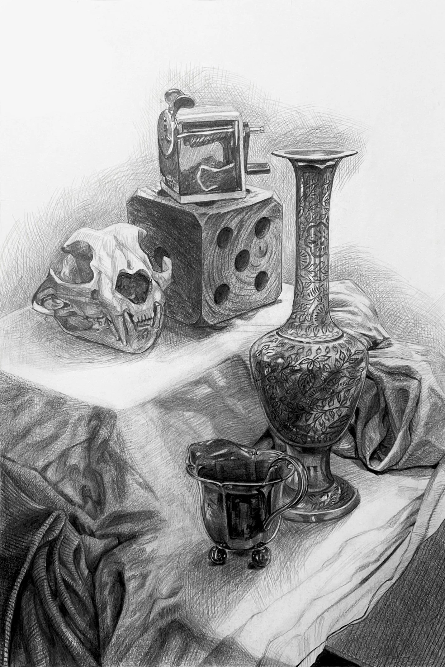 A pencil sketch of a still life arrangement featuring a human skull, a large decorative dice, a patterned vase, two cups, and folded cloth on a table.