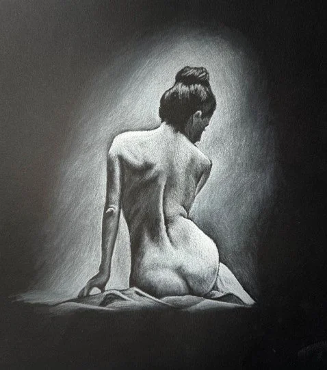 A black-and-white drawing of a woman with her hair in a bun, sitting on a surface, facing away, with her back exposed.