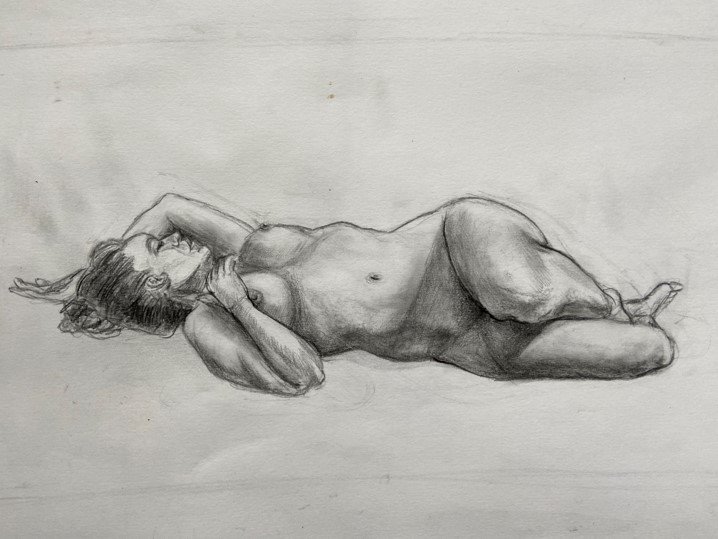 A realistic pencil sketch of a nude woman lying on her side with her hand resting on her head and her legs crossed at the ankles.
