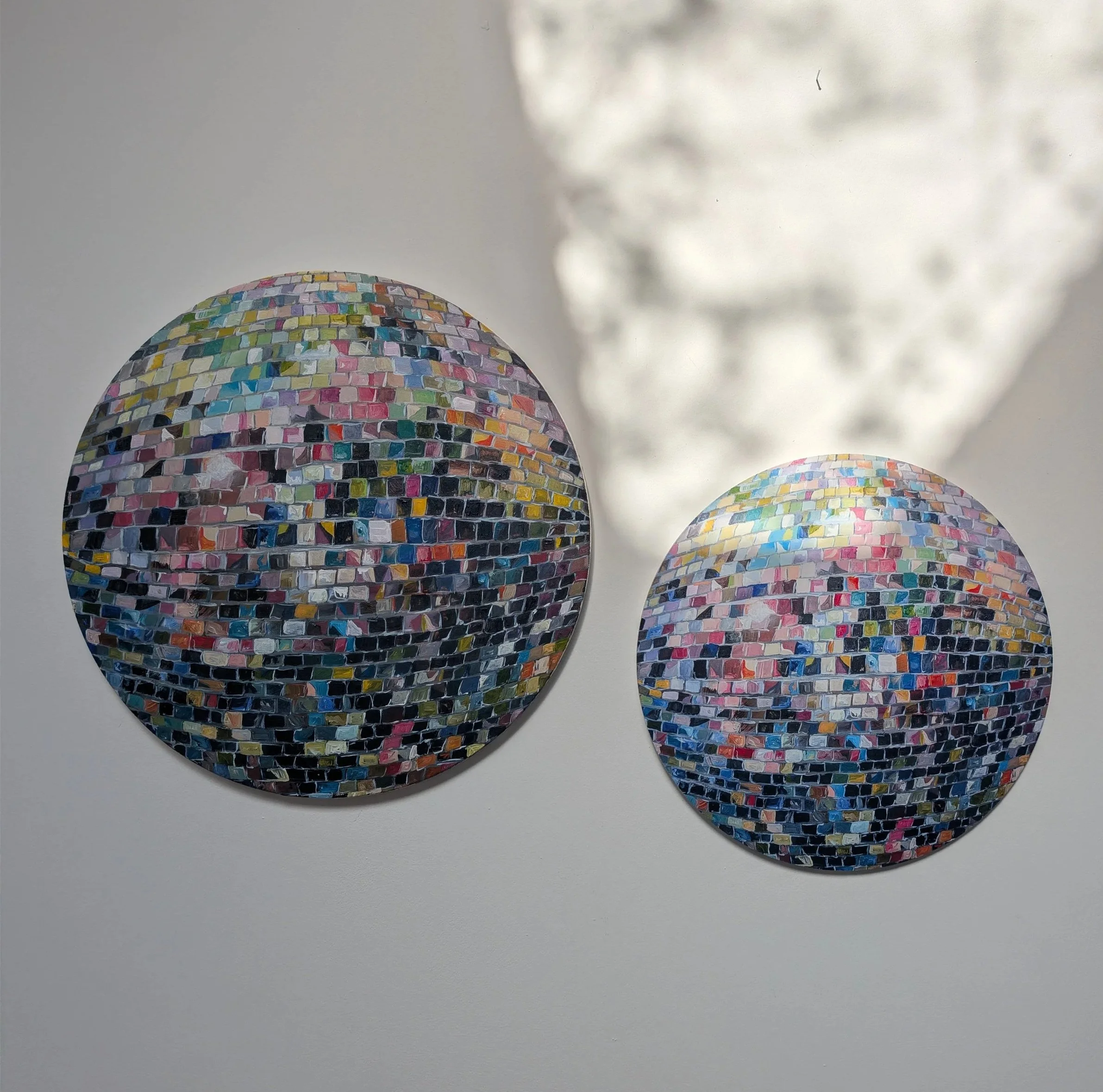 Close-up of three colorful mosaic balls with a white background.