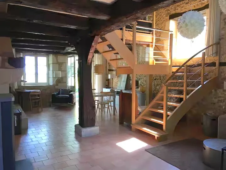 Le salon avec escalier en bois menant à la mezzanine