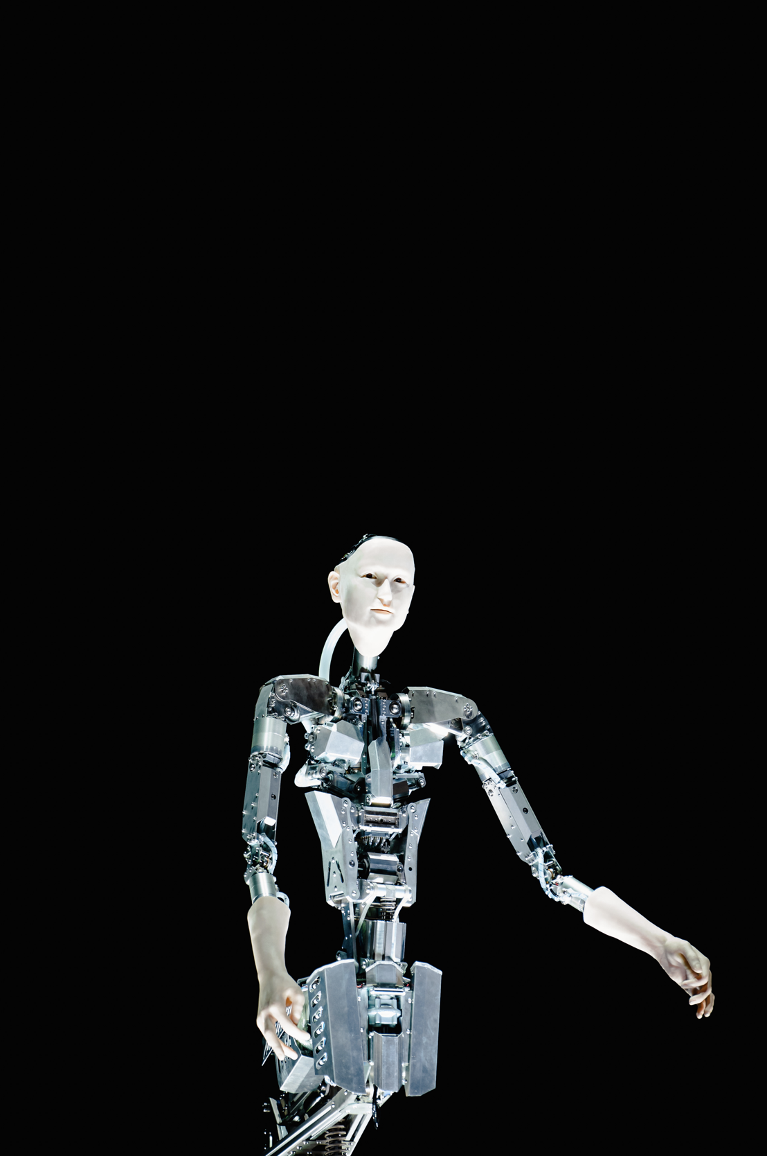 Un robot humanoïde avec un visage humain, en métal, dans un espace noir.