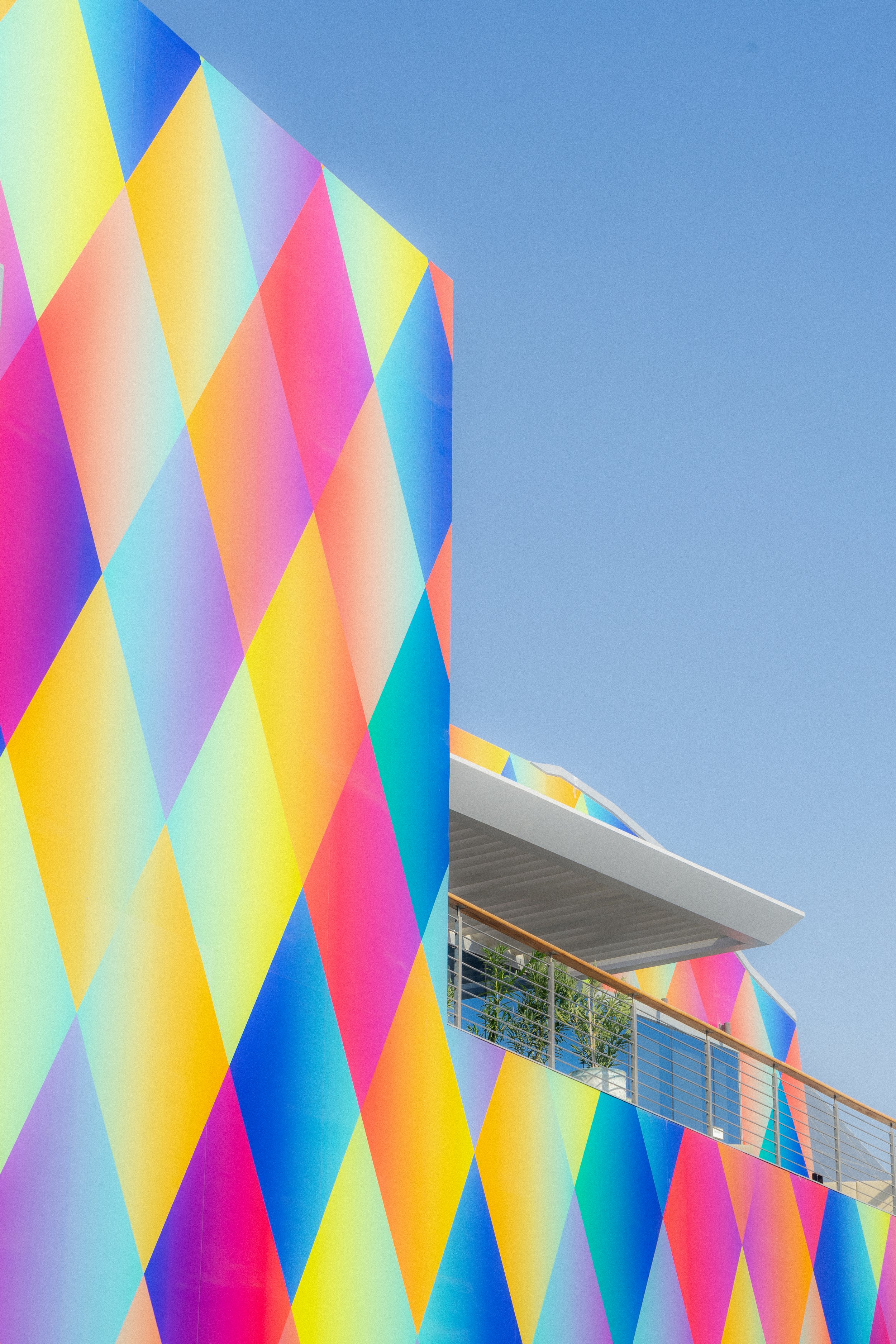 Façade colorée d'un bâtiment moderne avec des motifs géométriques en triangles multicolores.