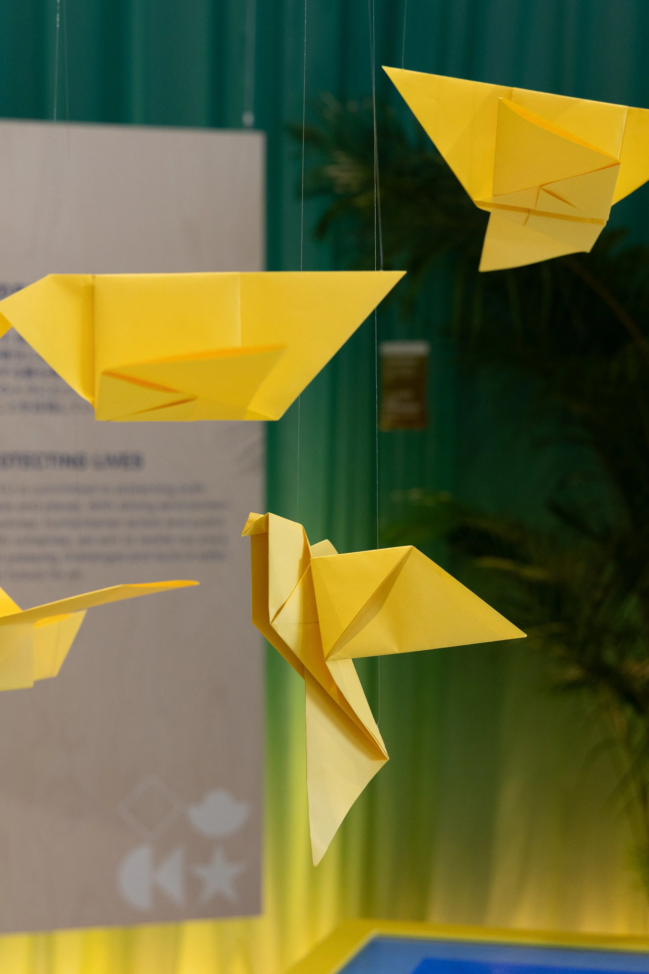 Des avions en papier jaunes suspendus dans l'air, semblant voler.