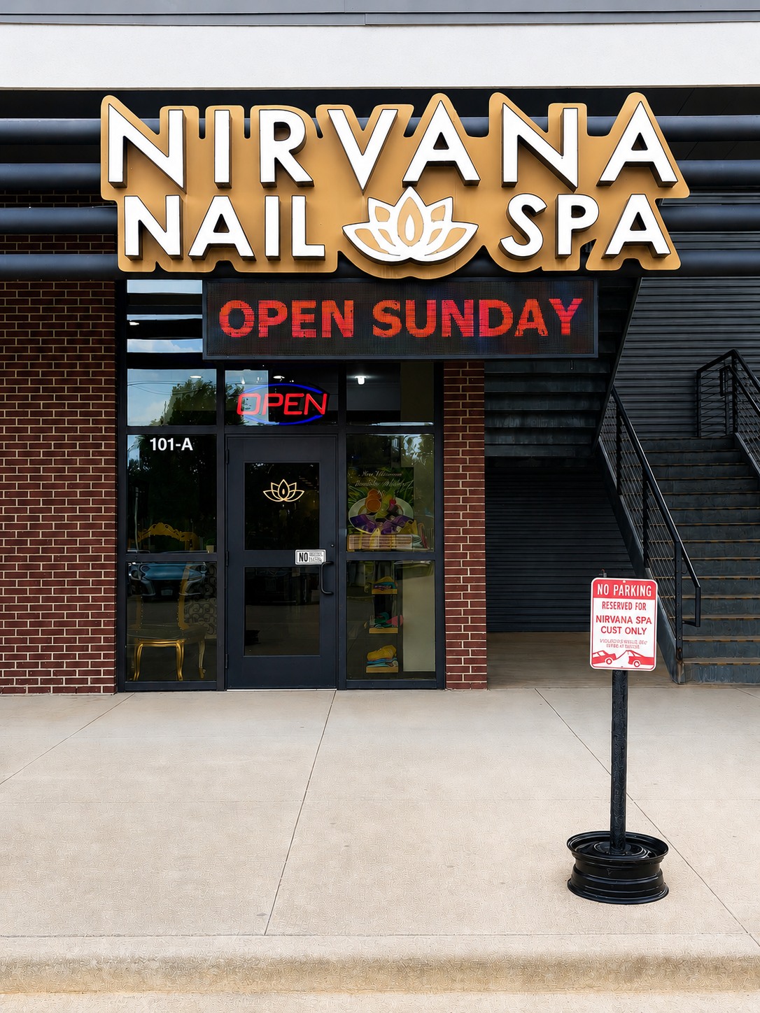 Exterior of Nirvana Nail Spa with a sign indicating it is open on Sunday, a neon 'Open' sign, and a reserved parking sign in front.
