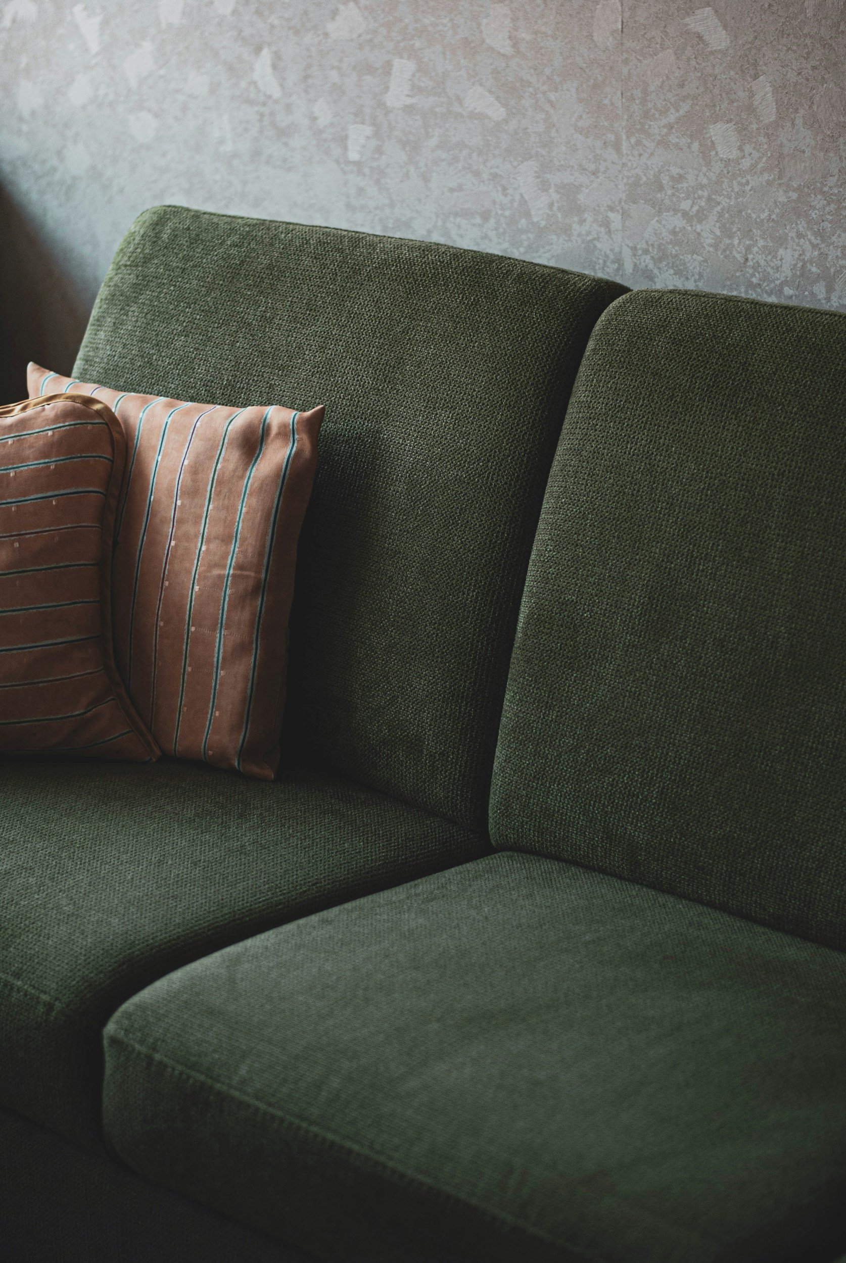 An image of a green couch where people could imagine themselves in a couples therapy session. people.