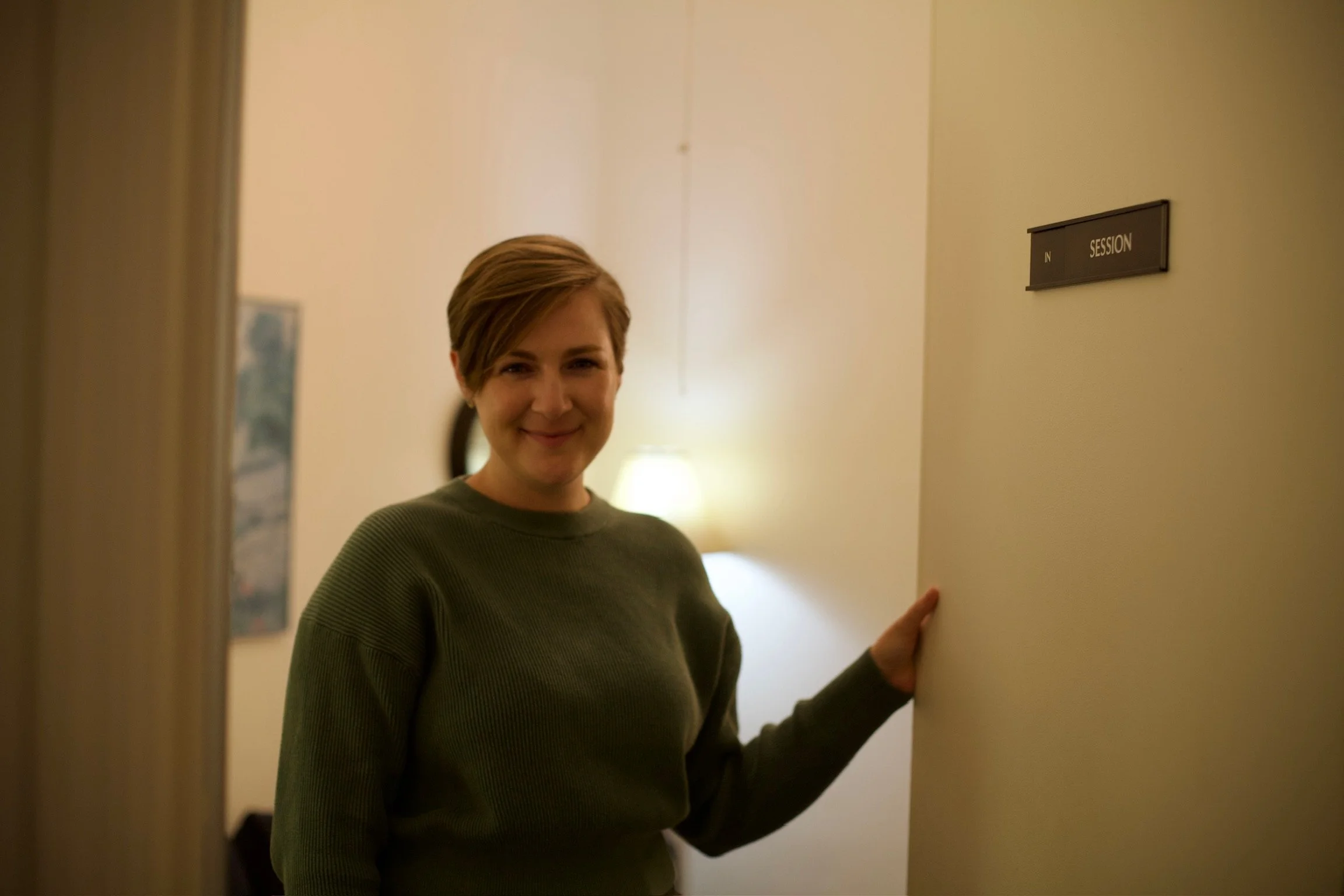 a photo of Leya smiling as she opens the door to her office