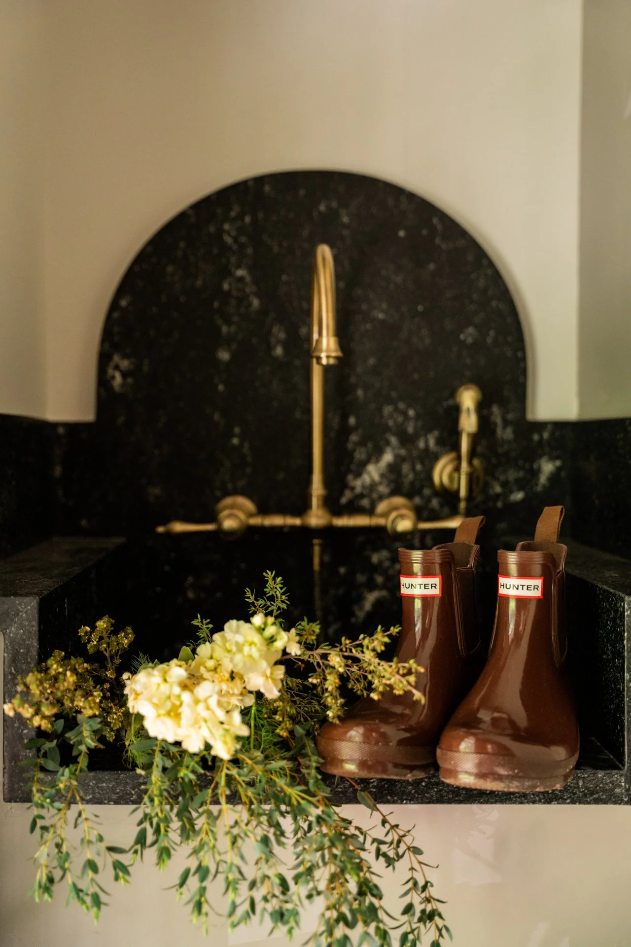 Wall mounted brass bridge faucet in laundry room