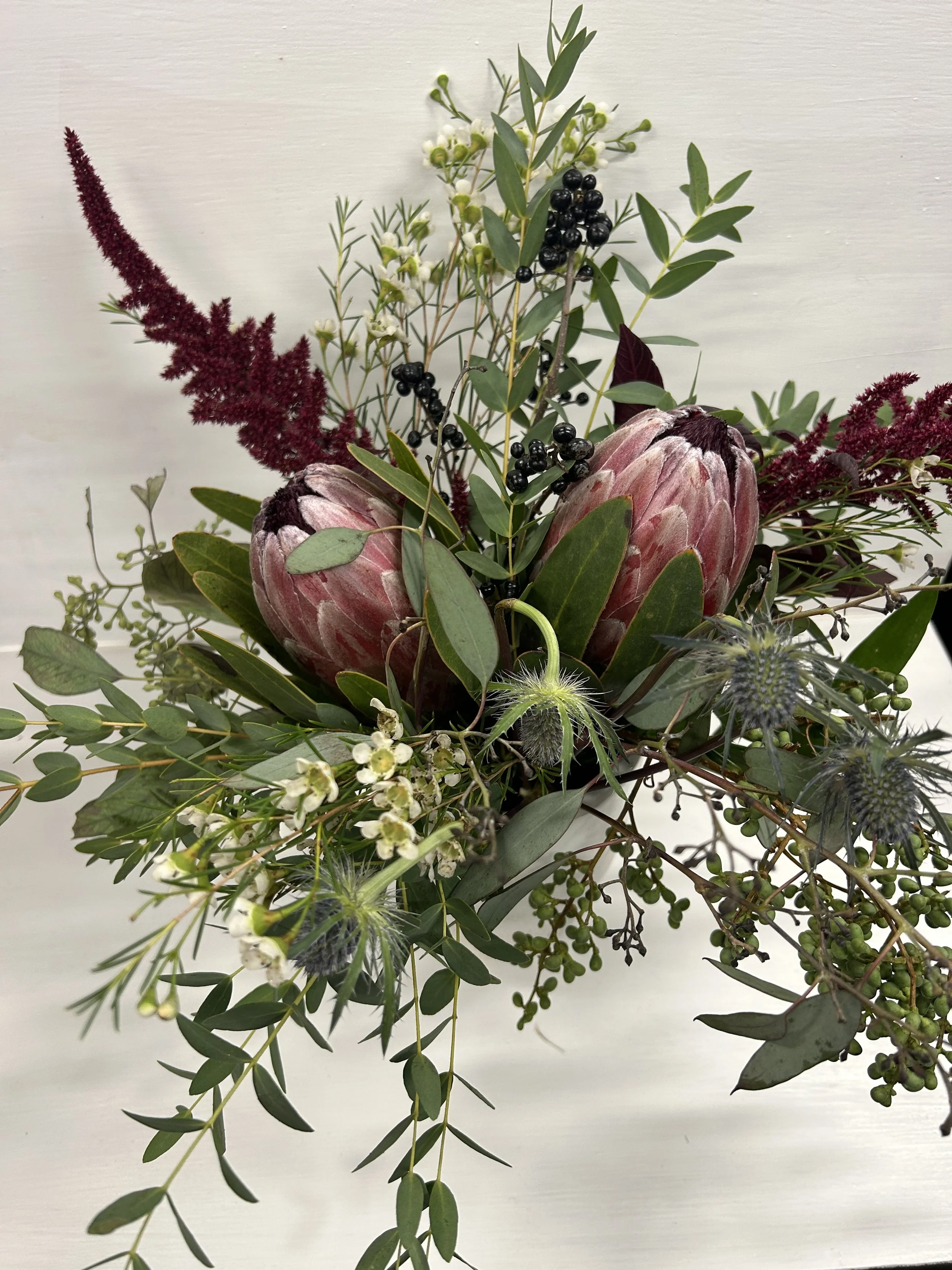 Protea, thistle, and amaranth floral arrangement, custom design by Well Gathered day-of coordinator