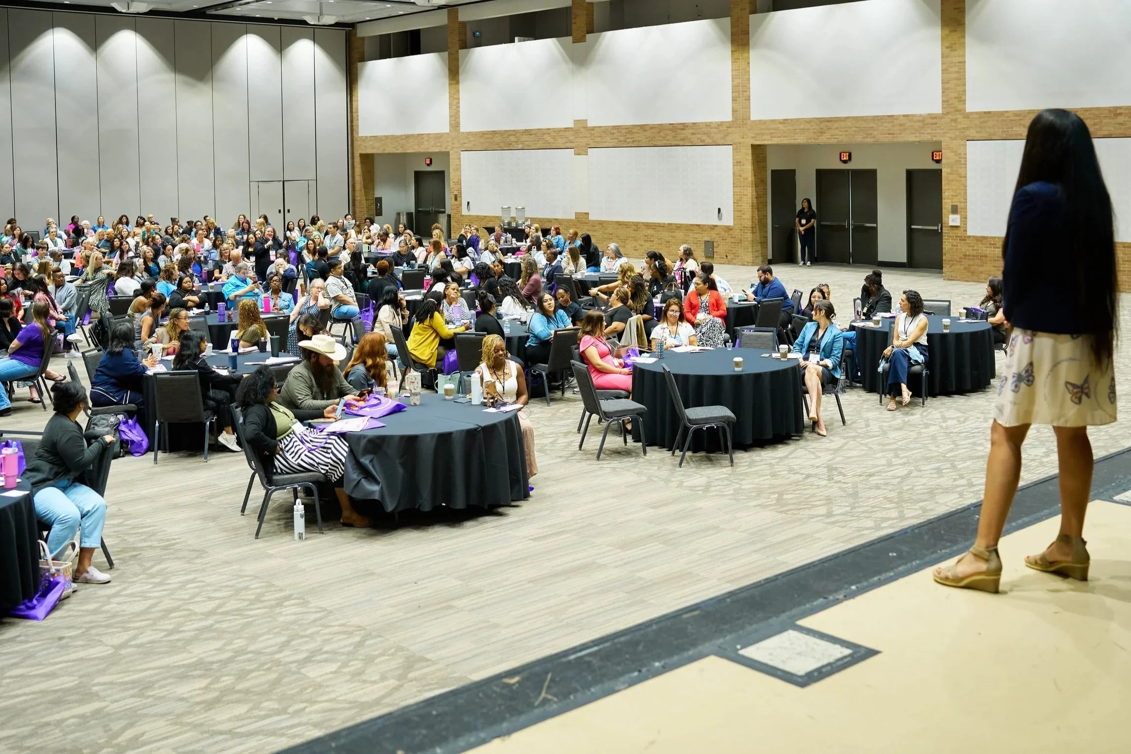 Willow Blythe-Carroll delivering a keynote to a large audience