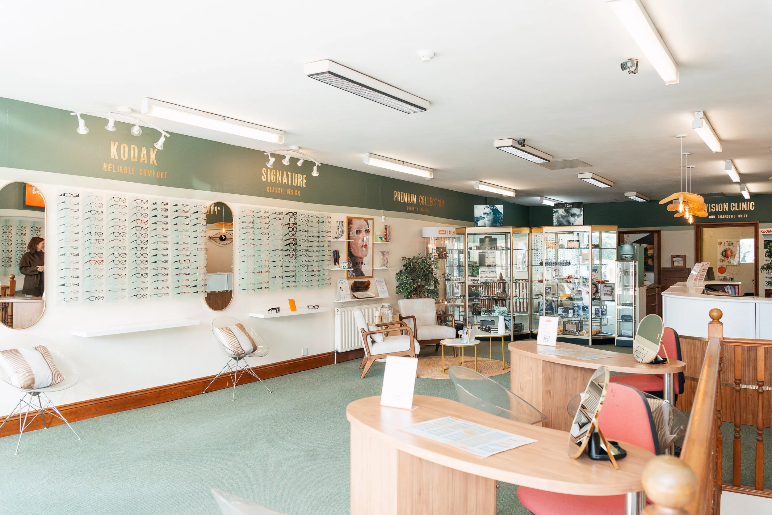Interior of an optometrist's office or optical shop with display shelves of eyeglasses and chairs for customers.