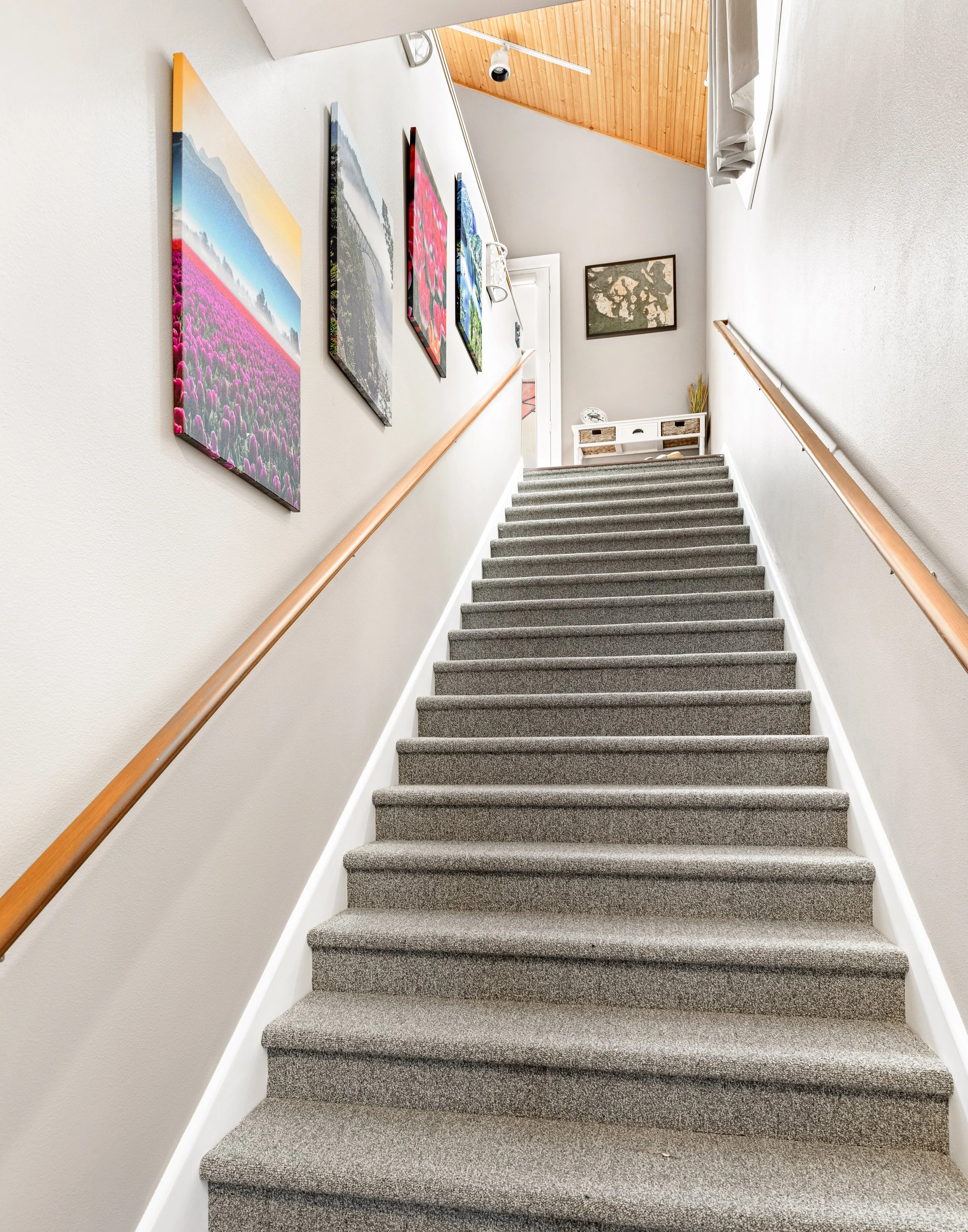 
Pacific Northwest gallery art lines the staircase to the main level.